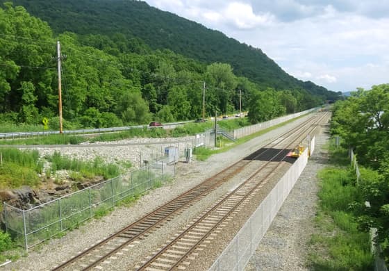 Breakneck Ridge station on the Metro-North Hudson Line: a short low platform beside the tracks, fenced off from the wooded hillside, with no shelter and no buildings.