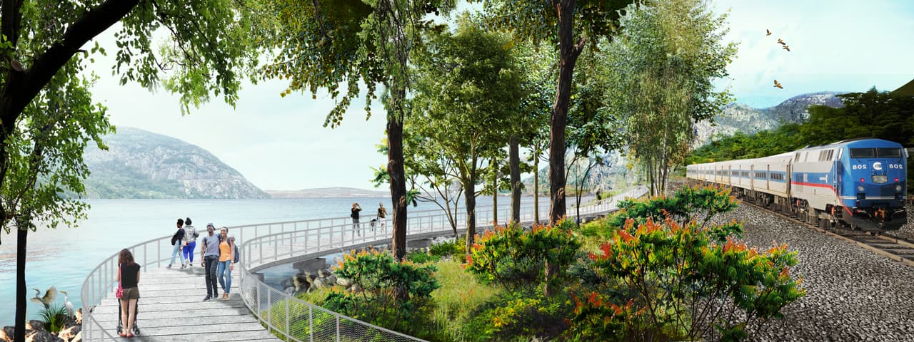 Wide artist's rendering of the proposed shoreline boardwalk: a timber deck carried out over the water on the left with walkers and cyclists on it, orange wildflowers planted along the landward edge, and a Metro-North train running past on the tracks immediately to the right.